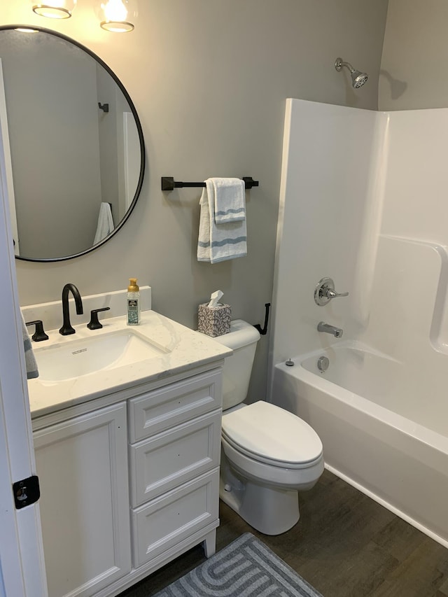 full bathroom featuring shower / washtub combination, toilet, hardwood / wood-style floors, and vanity