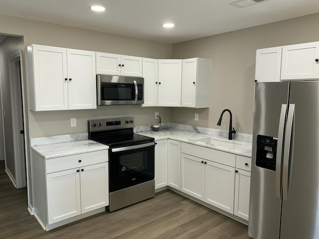 kitchen featuring stainless steel appliances, sink, and white cabinets