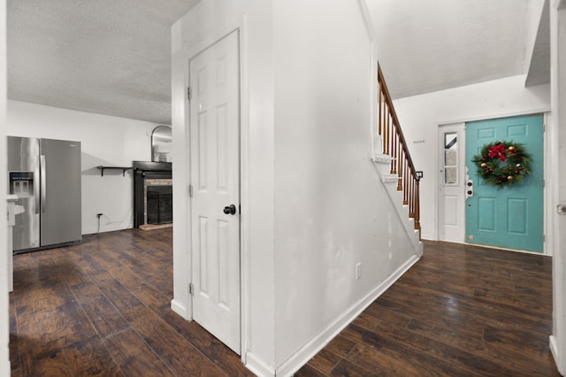 foyer entrance featuring a textured ceiling and dark hardwood / wood-style floors