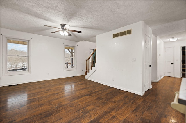 empty room with a textured ceiling, ceiling fan, and dark hardwood / wood-style floors