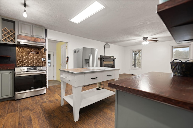 kitchen featuring a textured ceiling, stainless steel appliances, gray cabinetry, and dark hardwood / wood-style floors