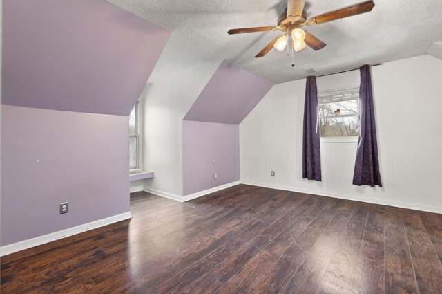 additional living space with lofted ceiling, ceiling fan, dark hardwood / wood-style flooring, and a textured ceiling