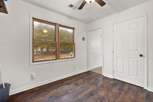 unfurnished bedroom featuring ceiling fan, dark hardwood / wood-style floors, and a textured ceiling