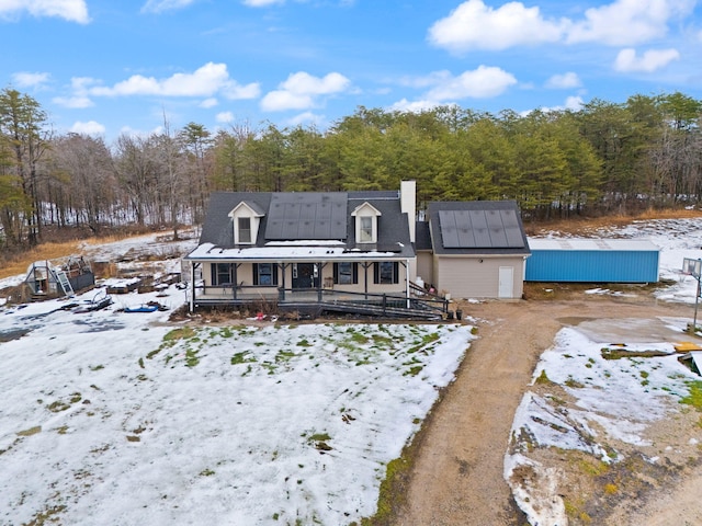 snow covered back of property with a porch