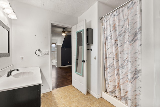 bathroom featuring a textured ceiling, a shower with shower curtain, and vanity