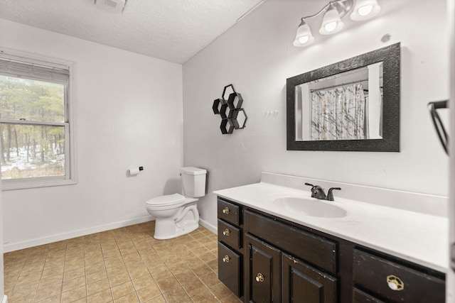 bathroom featuring a textured ceiling, toilet, and vanity