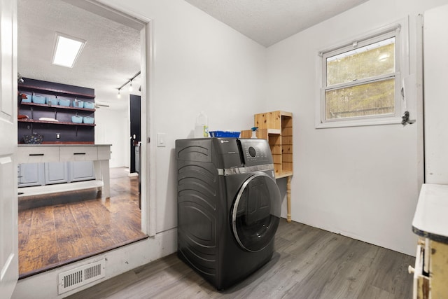 laundry room with a textured ceiling, hardwood / wood-style floors, and washer / clothes dryer