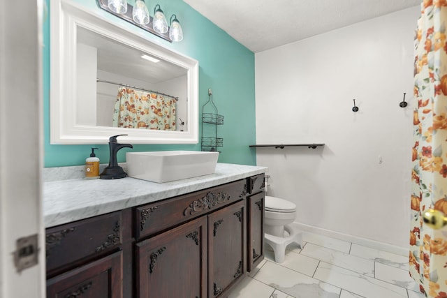 bathroom with toilet, vanity, and a textured ceiling