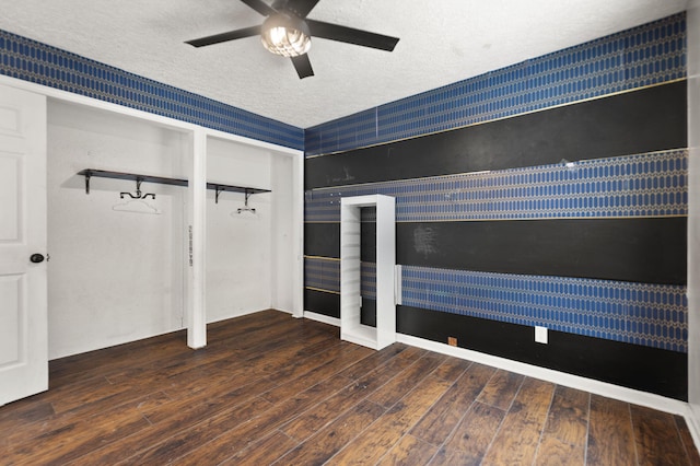 spare room with ceiling fan, dark wood-type flooring, and a textured ceiling