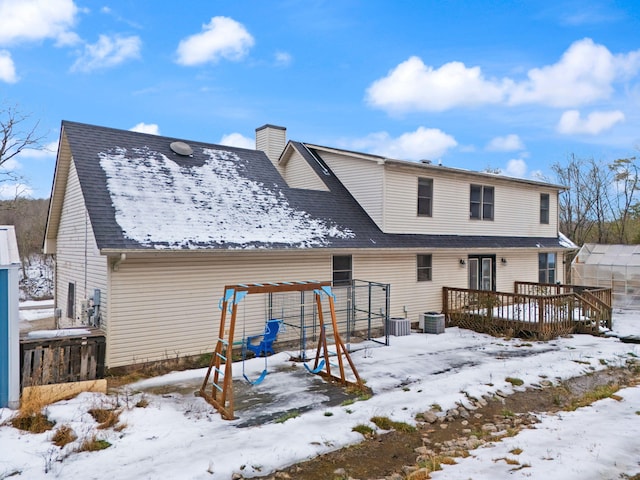 snow covered back of property featuring a wooden deck and cooling unit