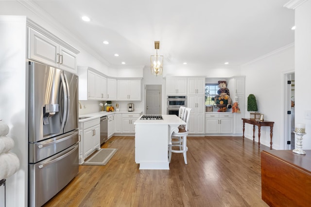 kitchen featuring a breakfast bar area, appliances with stainless steel finishes, white cabinetry, and a kitchen island