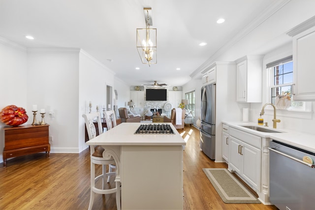 kitchen with stainless steel appliances, white cabinets, and sink