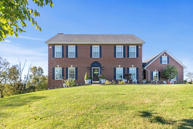 colonial home featuring a front lawn