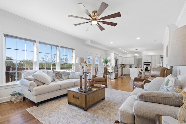 living room featuring plenty of natural light, light hardwood / wood-style flooring, and crown molding