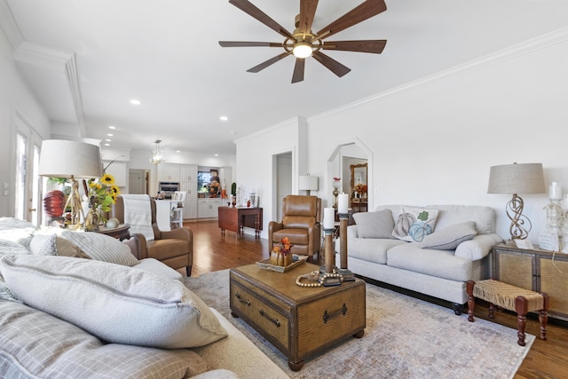 living room featuring hardwood / wood-style flooring, crown molding, and ceiling fan