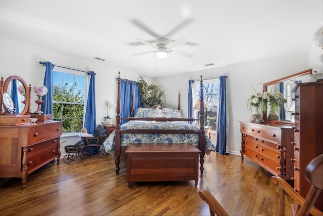 bedroom featuring ceiling fan, multiple windows, and hardwood / wood-style flooring