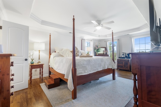 bedroom featuring a raised ceiling, ceiling fan, ornamental molding, and hardwood / wood-style floors