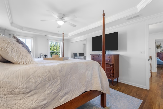 bedroom with ceiling fan, dark hardwood / wood-style flooring, ornamental molding, and a raised ceiling