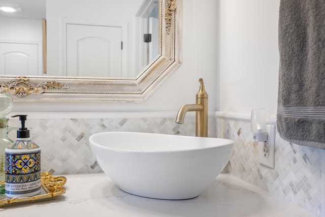 bathroom featuring sink and tile walls