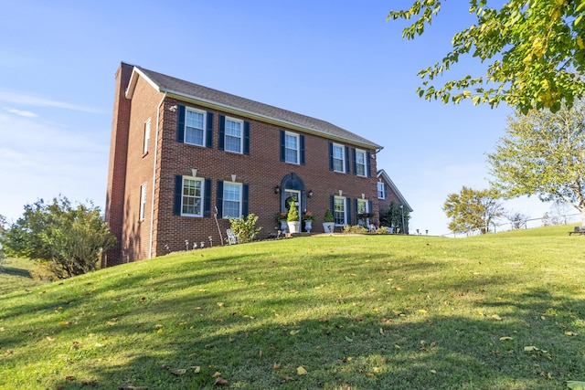 colonial house featuring a front lawn