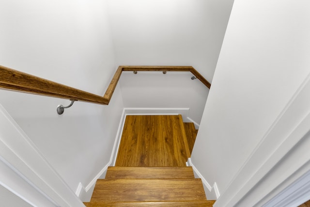 stairs featuring hardwood / wood-style floors