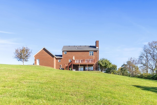 back of property featuring a deck and a yard