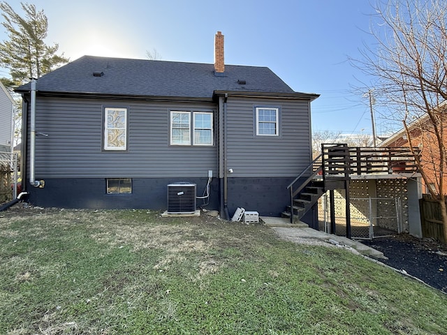 rear view of property with central AC and a yard