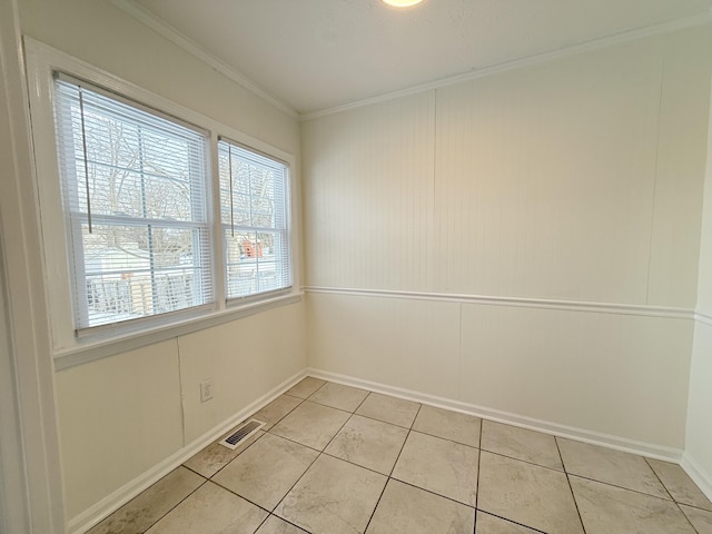 unfurnished room featuring crown molding and light tile patterned floors