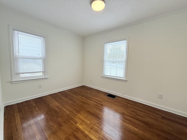 empty room with dark wood-type flooring, crown molding, and a textured ceiling