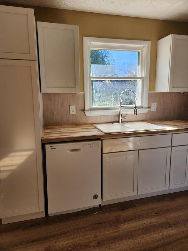 kitchen with sink, dishwasher, white cabinets, and dark hardwood / wood-style floors