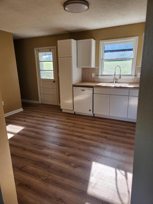 kitchen featuring dishwasher, sink, white cabinets, dark hardwood / wood-style floors, and decorative backsplash