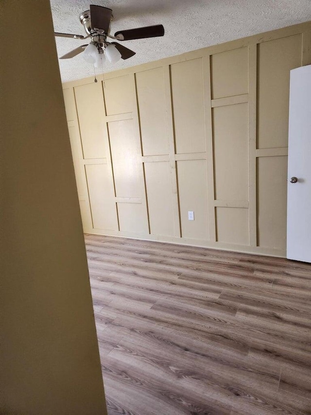 unfurnished bedroom with ceiling fan, a textured ceiling, and light hardwood / wood-style flooring