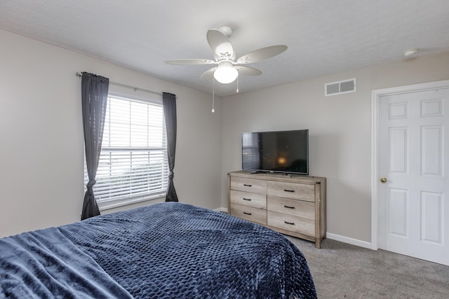 bedroom featuring a textured ceiling, carpet floors, and ceiling fan