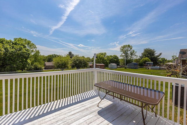 wooden deck featuring a yard and a shed