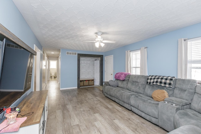 living room with hardwood / wood-style flooring, ceiling fan, a healthy amount of sunlight, and a textured ceiling