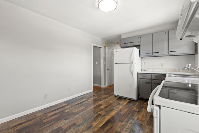 kitchen featuring gray cabinetry, sink, white appliances, and dark hardwood / wood-style flooring