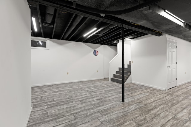 basement with light hardwood / wood-style flooring