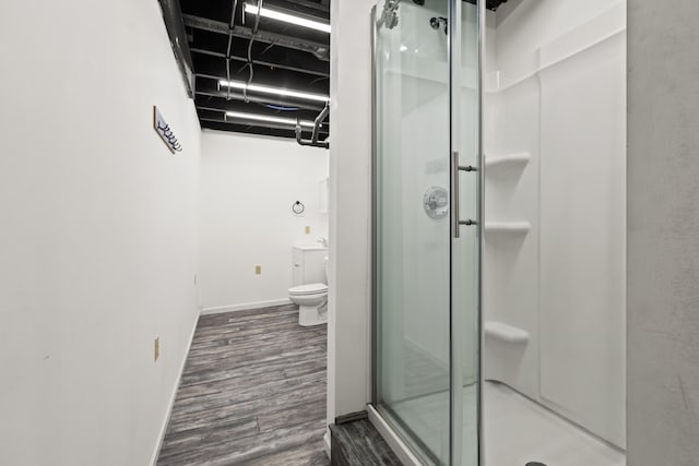 bathroom featuring vanity, hardwood / wood-style floors, a shower with door, and toilet