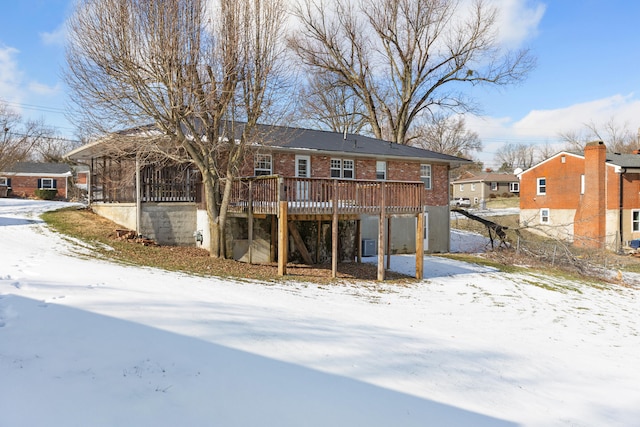 snow covered house featuring a wooden deck