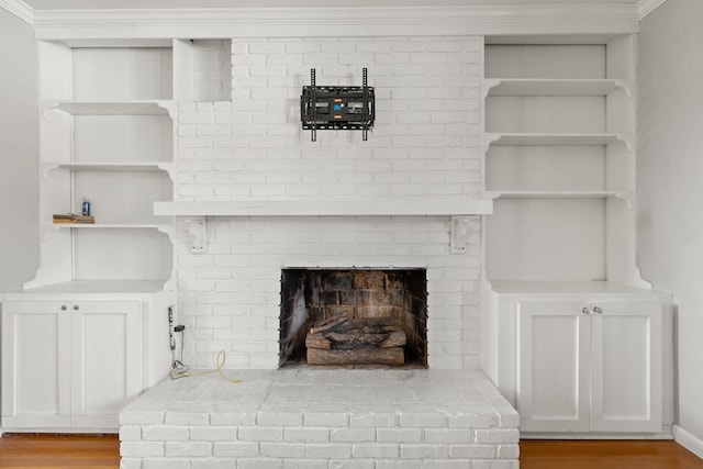 room details with hardwood / wood-style floors, crown molding, and a brick fireplace