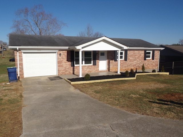 ranch-style home with an attached garage, driveway, a front lawn, and brick siding