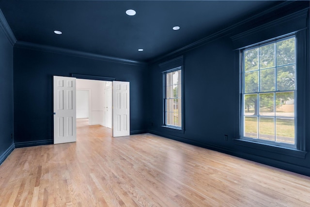 spare room with light hardwood / wood-style flooring, ornamental molding, and plenty of natural light