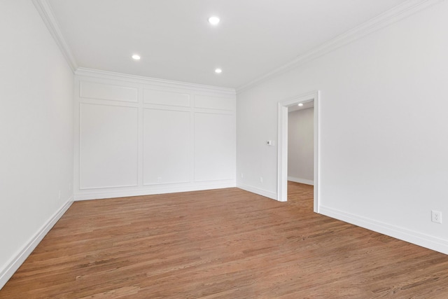 empty room featuring ornamental molding and hardwood / wood-style floors