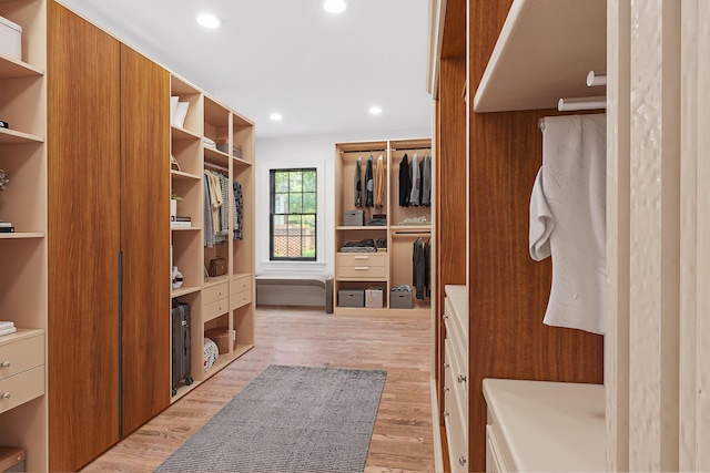 walk in closet with light hardwood / wood-style floors