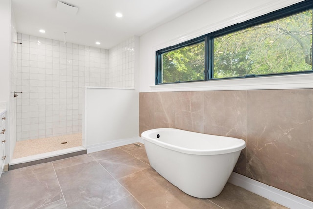 bathroom with plus walk in shower, tile patterned flooring, and vanity