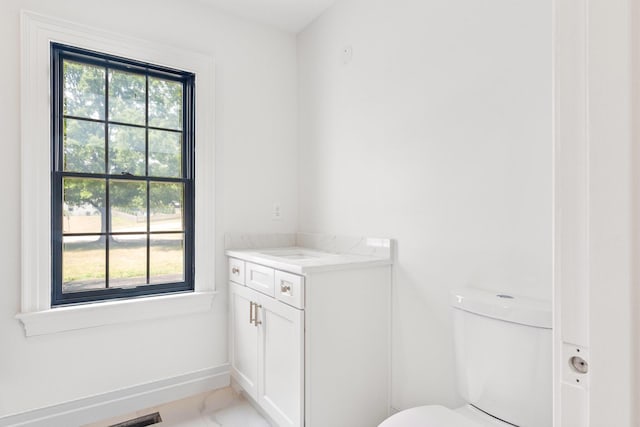 bathroom featuring a wealth of natural light, toilet, and vanity