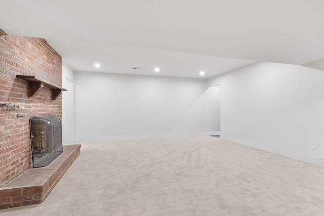 basement featuring light colored carpet and a wood stove