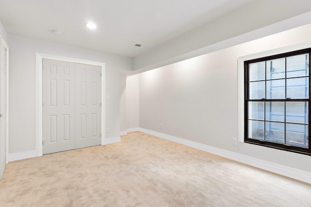 unfurnished bedroom with a closet and light carpet