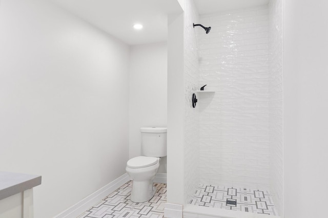 bathroom featuring tiled shower, toilet, and tile patterned floors