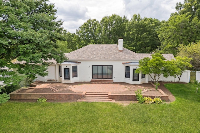 back of property with a patio area and a lawn